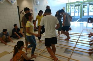KOM youth practice the bamboo dance during the summer in the school hallway